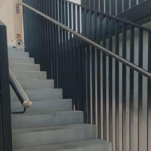 Metal handrail with armrest for staircase